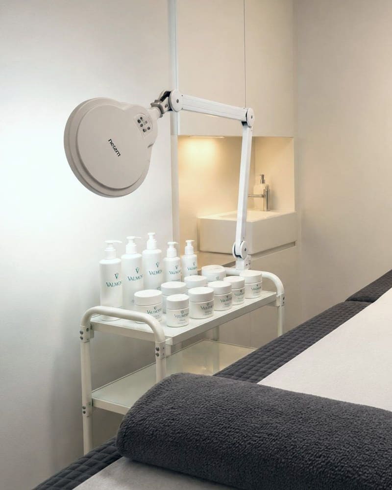 A treatment room at Pure Essentials London with a trolley of products
